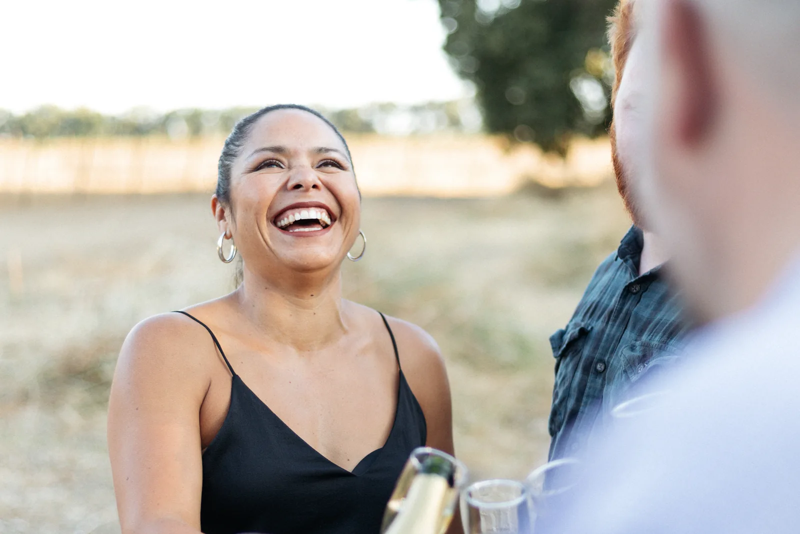 Friends laughing together over glasses of Rescue Dog Wines